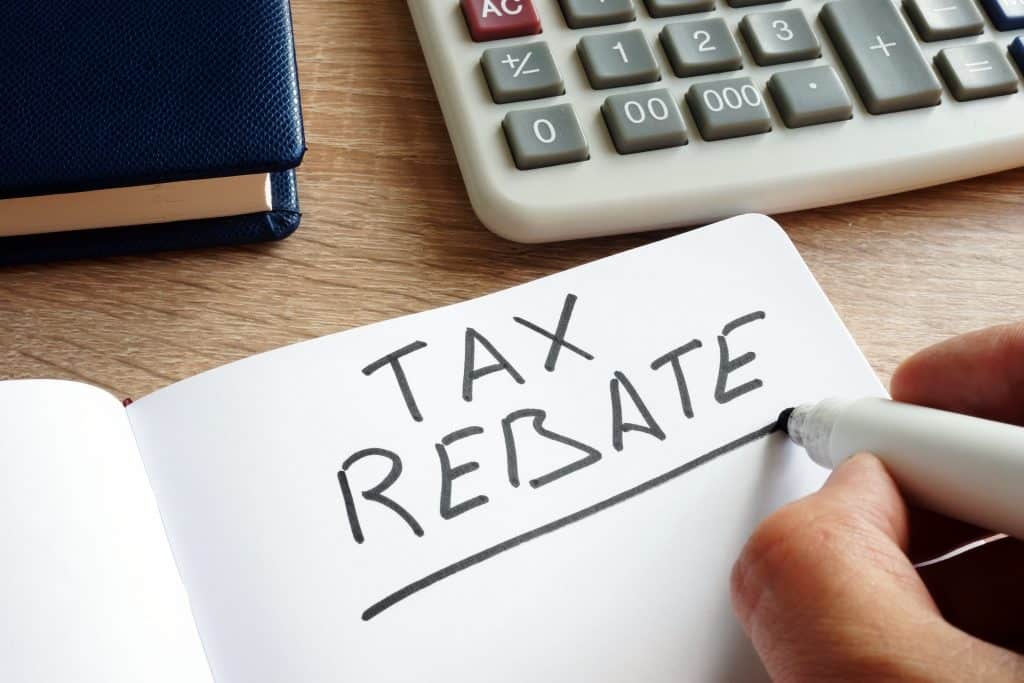 person with calculator writing tax rebate