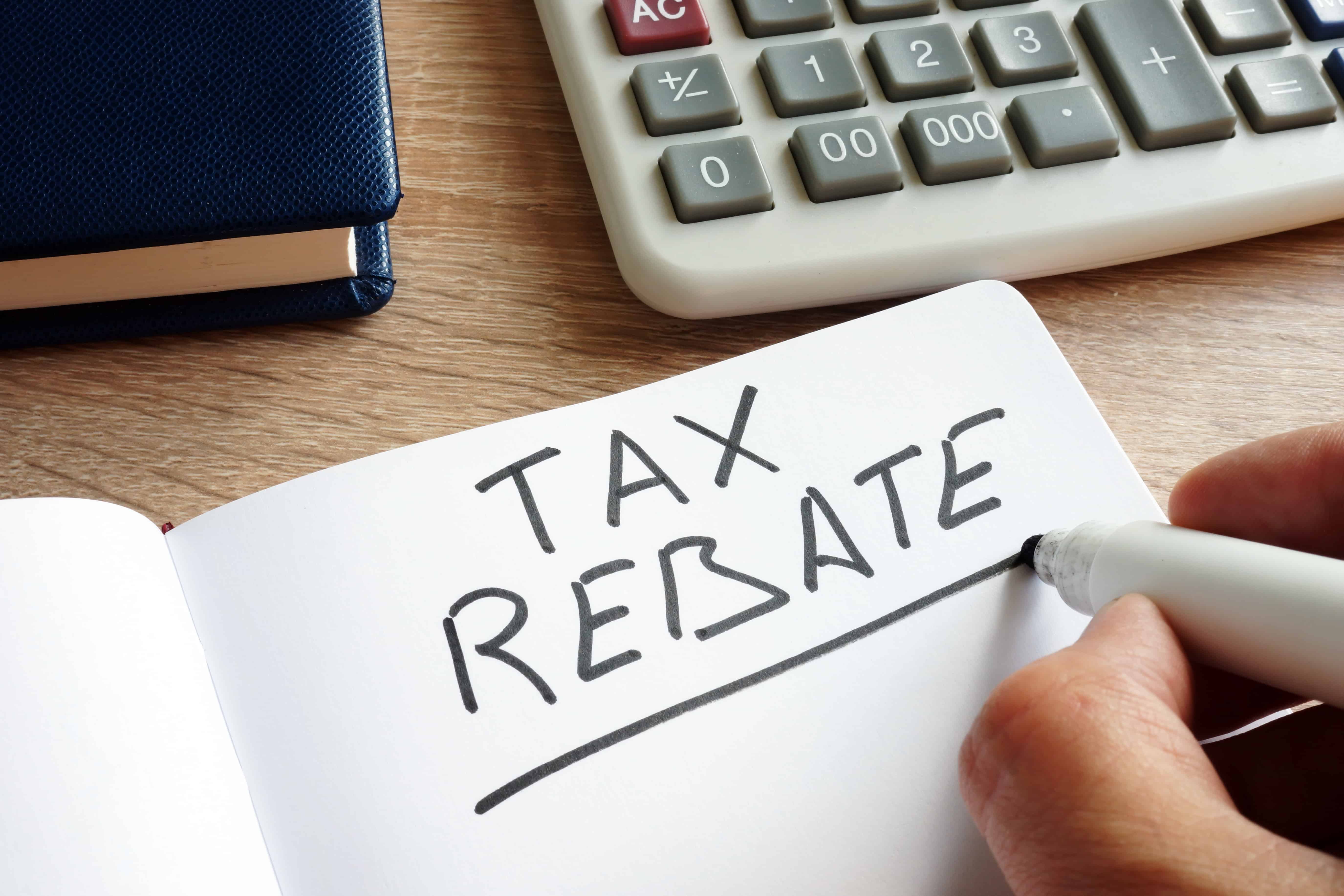 person with calculator writing tax rebate